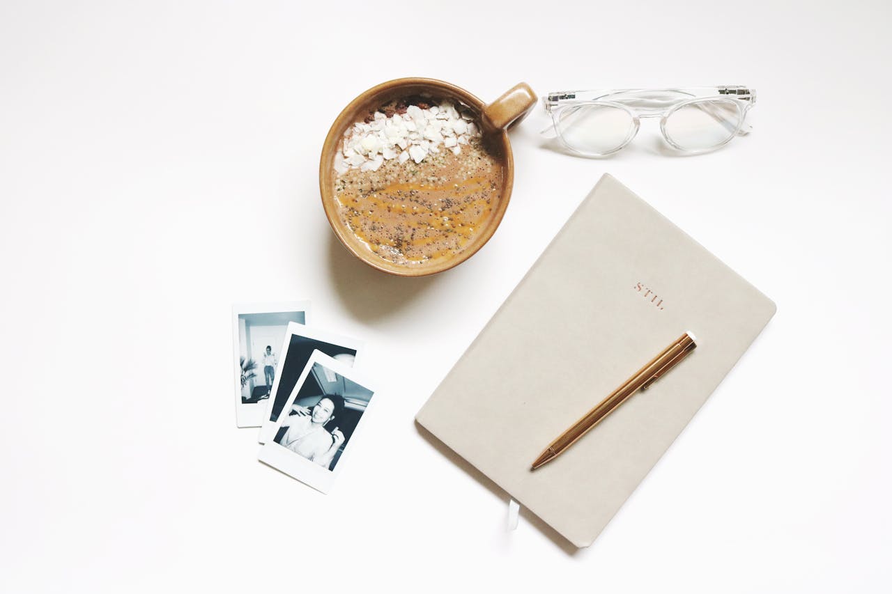 our-services-1 Minimalist flatlay featuring a coffee, notebook, eyeglasses, and photographs.